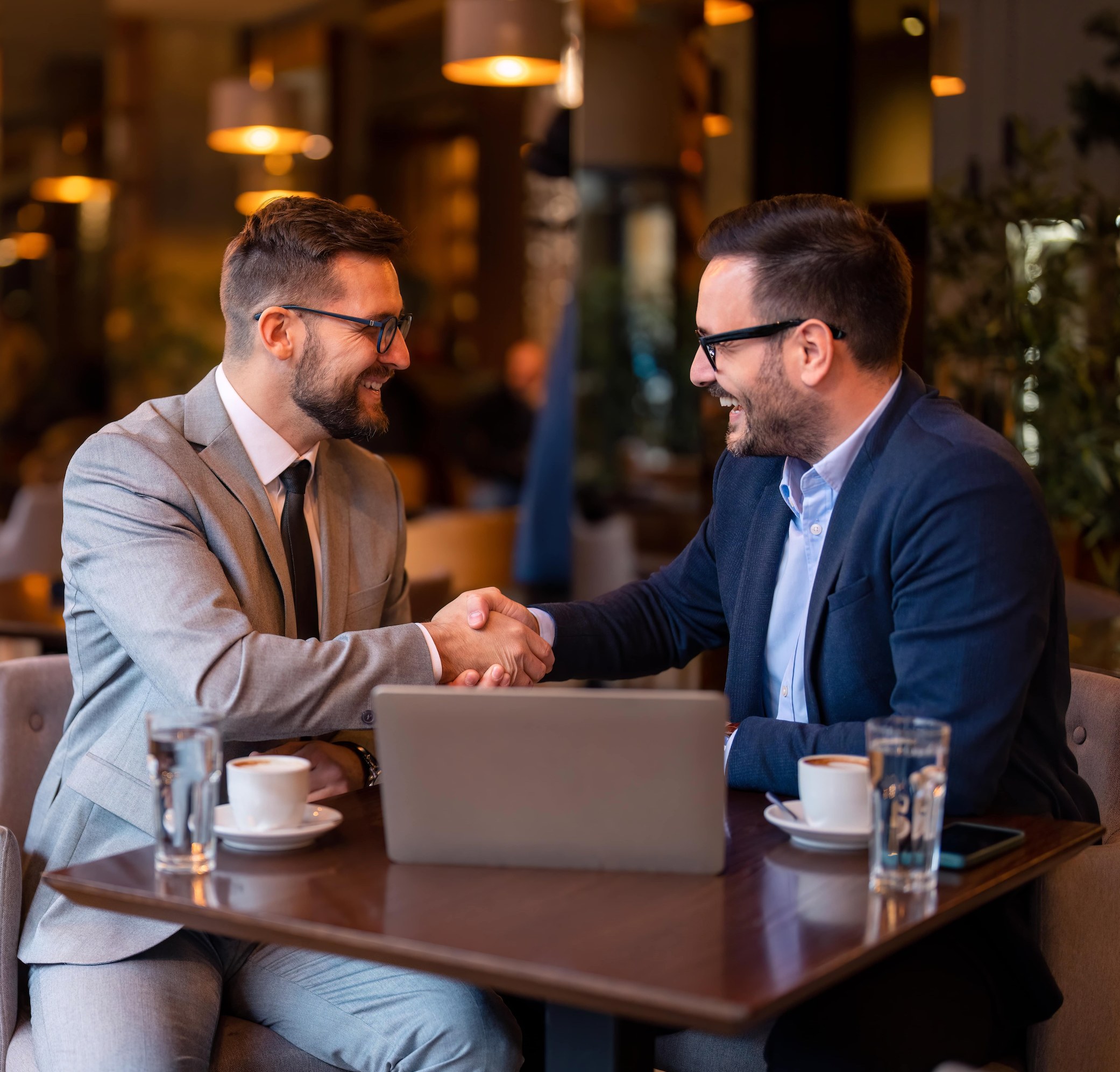 Business professionals shaking hands at a meeting in a restaurant.