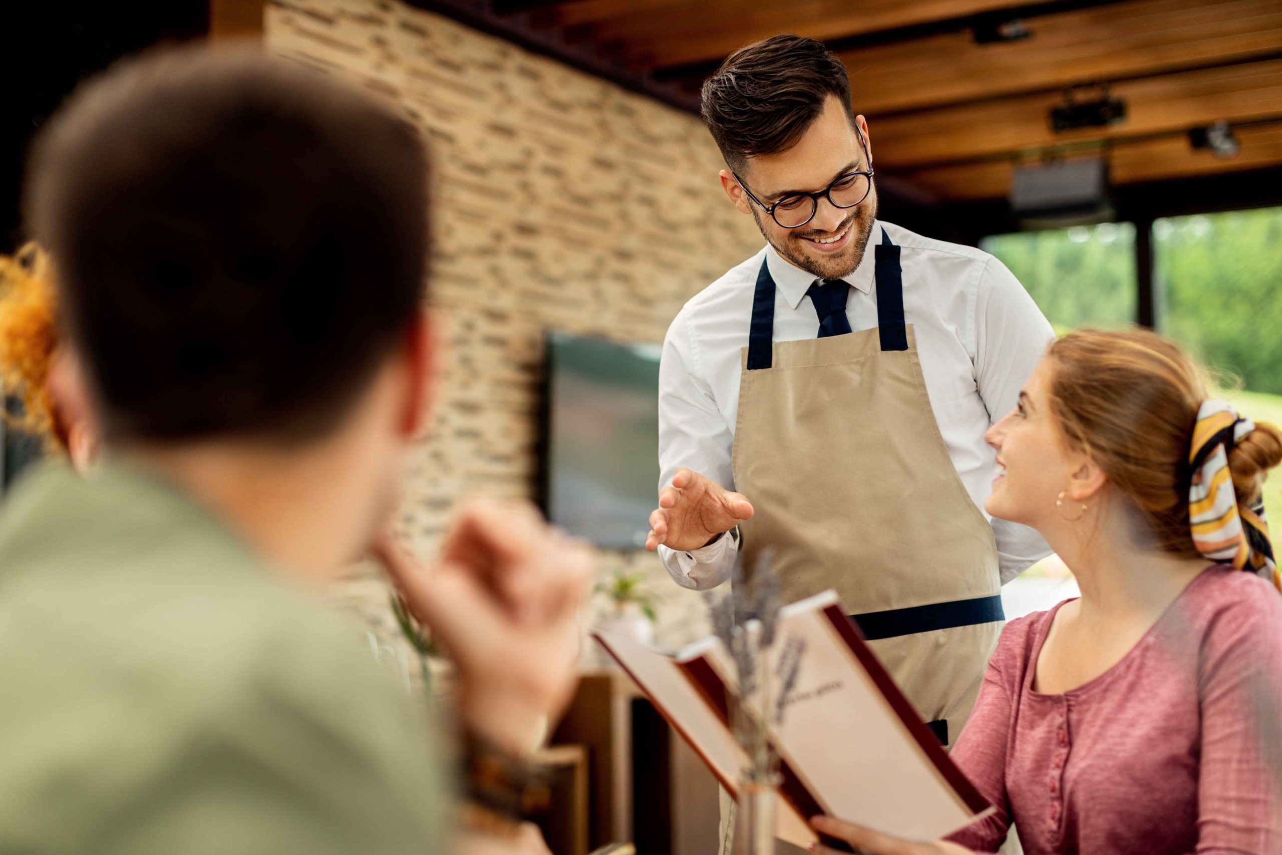 Service staff engaging with customers in a restaurant setting.
